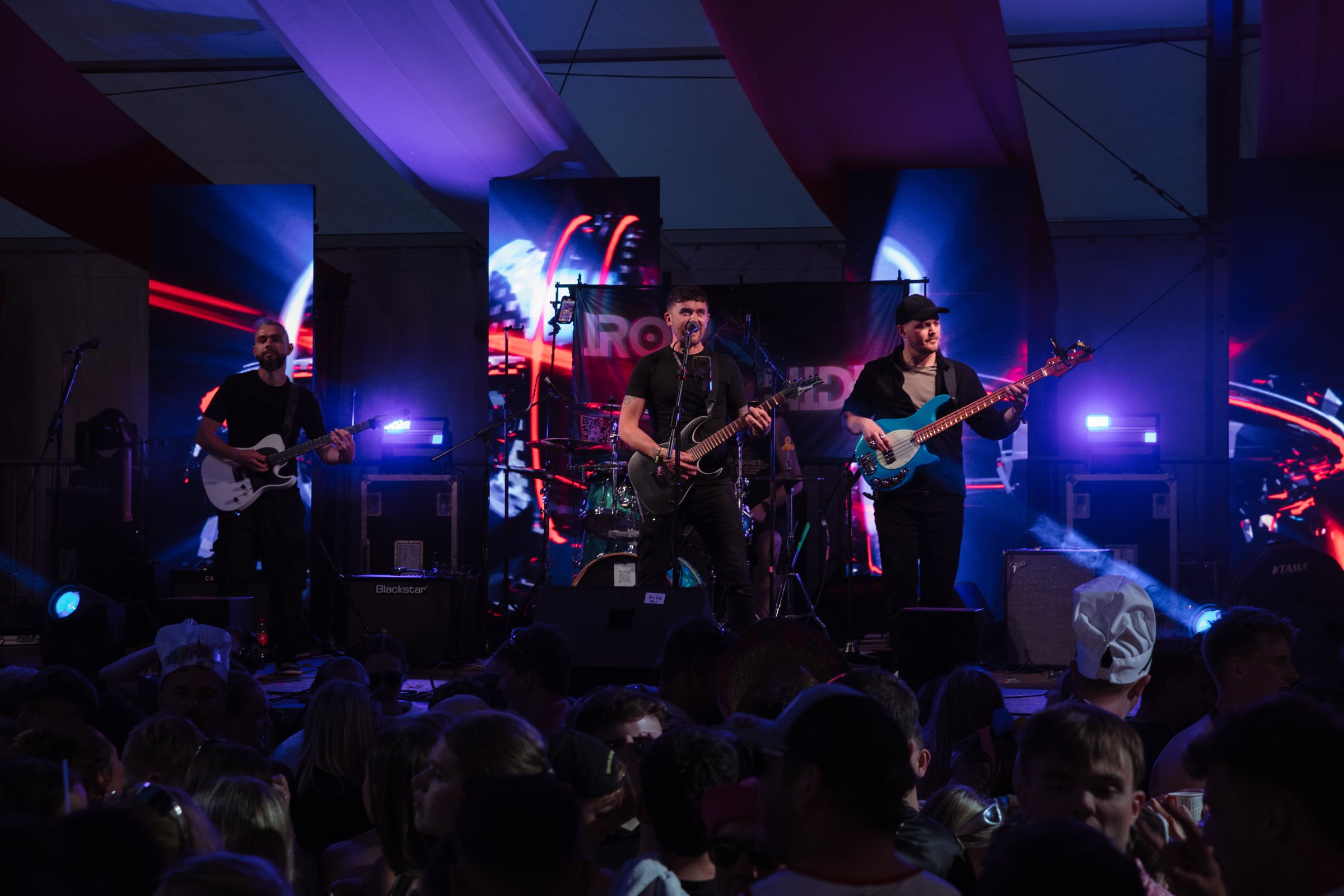 Ironhide live, blue light, crowd in the foreground and the IRONHIDE backdrop